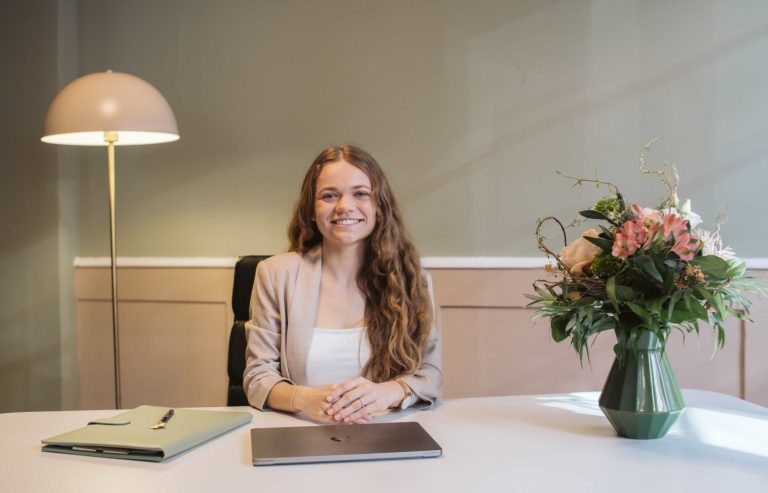 Ballon mit der Aufschrift "love", umgeben von bunten Pompons und einer blühenden Landschaft.