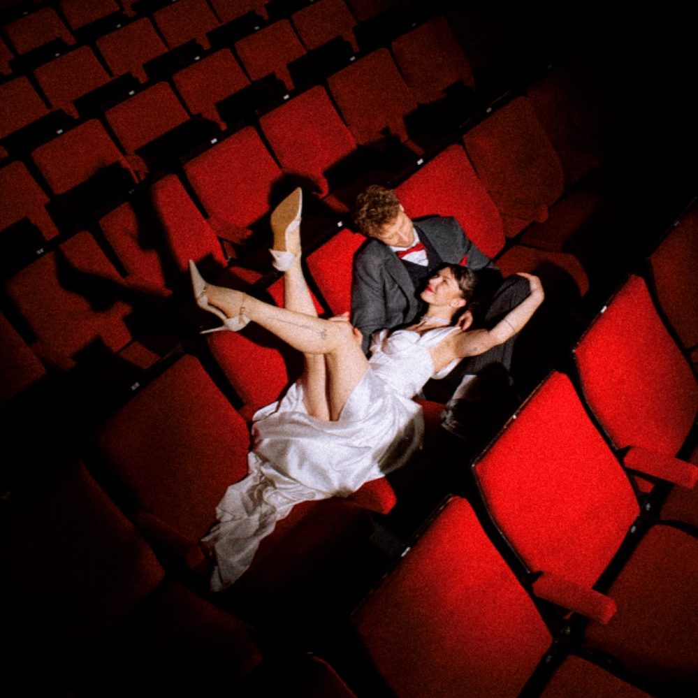 Gläser werden angehoben, um anzustoßen, mit Konfetti im Hintergrund.